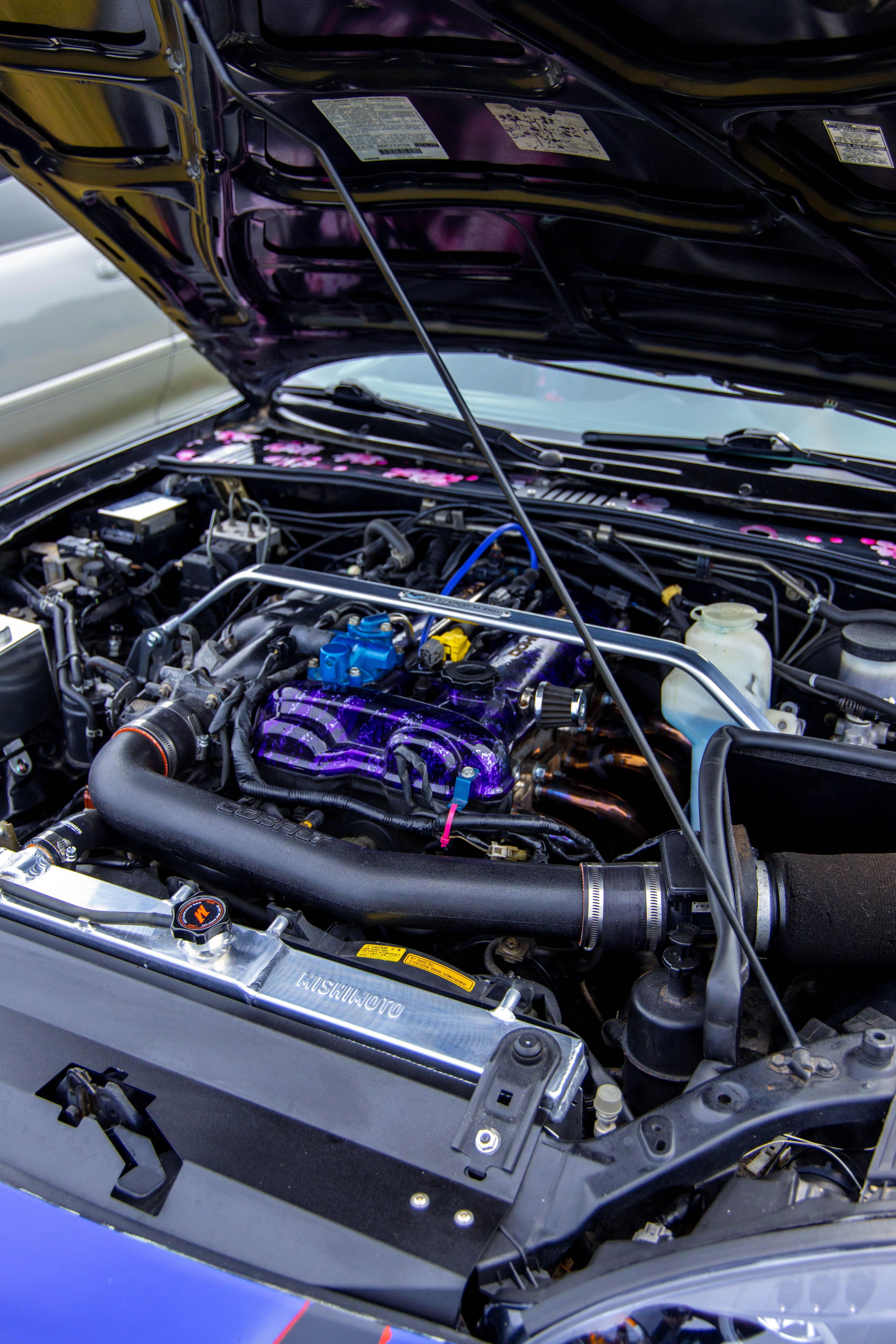 Engine bay of a modified car with a polished intake manifold and aluminium radiator