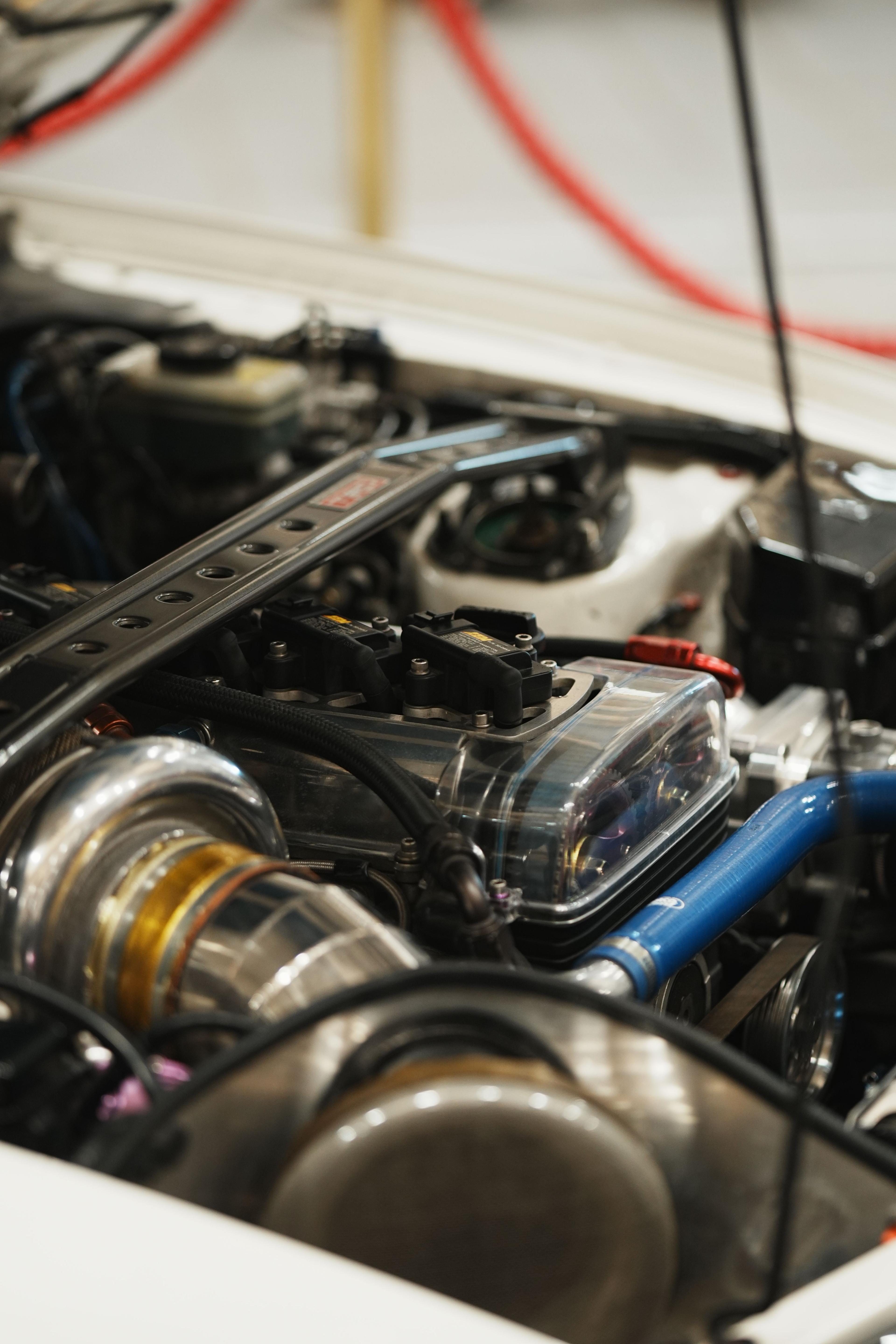 Close-up of a turbocharged engine with coil packs, braided lines and chrome charge piping